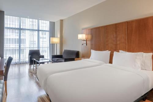 ein großes weißes Bett in einem Hotelzimmer in der Unterkunft AC Hotel Aitana by Marriott in Madrid