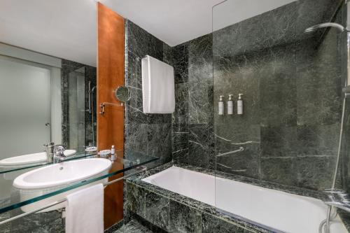 a bathroom with a bath tub and a sink at AC Hotel Aitana by Marriott in Madrid