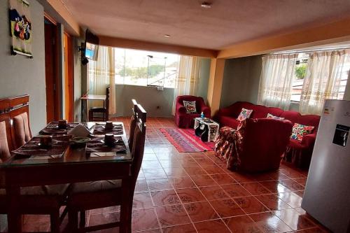 a living room with a table and a red couch at Casa Mirador SanBlas in Cusco