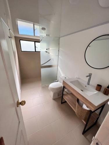 La salle de bains est pourvue d'un lavabo, de toilettes et d'un miroir. dans l'établissement Casa de campo San Juan del Puente en Villeta, à Villeta