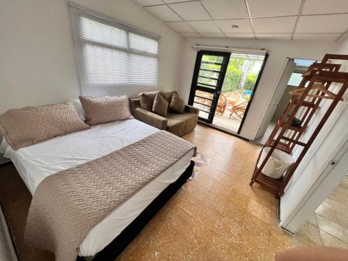 - une chambre avec un lit, une chaise et une échelle dans l'établissement Casa de campo San Juan del Puente en Villeta, à Villeta