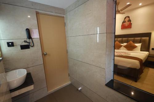 a bathroom with a bed and a sink and a mirror at Goodland Elegance in Trivandrum