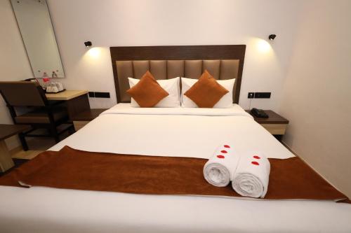 a bedroom with a bed with two towels on it at Goodland Elegance in Trivandrum