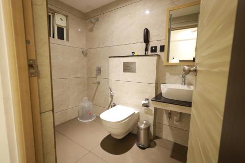 a bathroom with a toilet and a sink at Goodland Elegance in Trivandrum