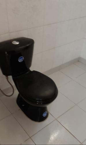 eine schwarze Toilette in einer Badezimmerkabine in der Unterkunft Departamento céntrico a 4 cuadras de la Plaza principal in Sucre