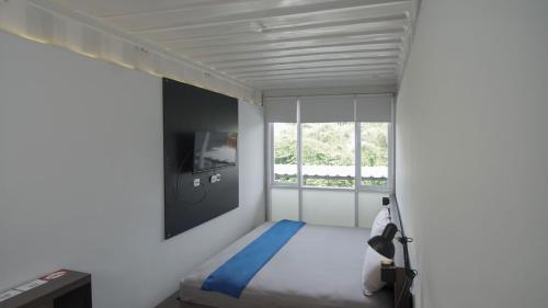 Habitación pequeña con cama y ventana en My Dormy Hostel UMM, en Sengkaling