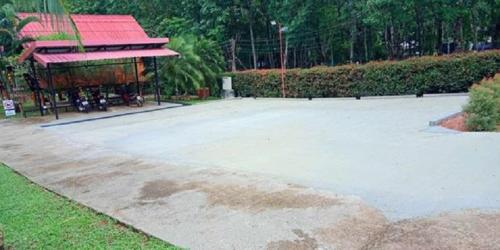 a large concrete parking lot with a building in the background at Najjamee Bungalows in Ko Yao Noi