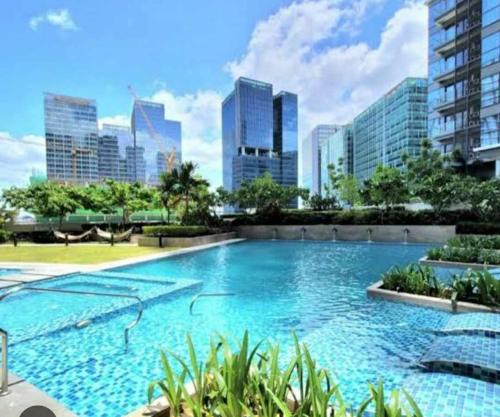una gran piscina con vistas al perfil urbano de fondo en Uptown Parksuites BGC, en Manila