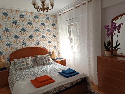 ein Schlafzimmer mit einem Bett, auf dem zwei Handtücher liegen in der Unterkunft Centro. Bahía. Estaciones. in Santander