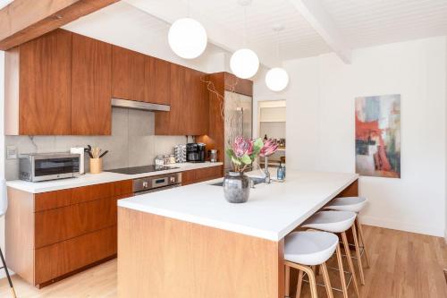 a kitchen with wooden cabinets and a white counter top at Secluded Forest Oasis - Your Ultimate Retreat Awaits! in Montara