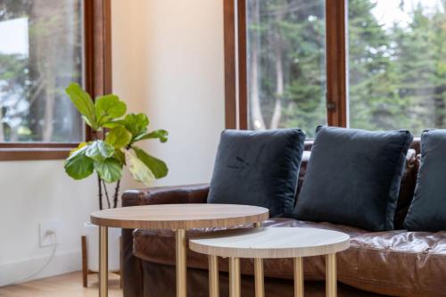 a living room with a couch and two tables at Secluded Forest Oasis - Your Ultimate Retreat Awaits! in Montara