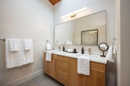 a bathroom with a sink and a large mirror at Secluded Forest Oasis - Your Ultimate Retreat Awaits! in Montara