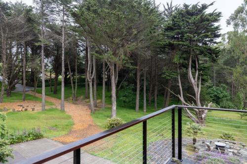 a balcony with a fence and trees in a park at Secluded Forest Oasis - Your Ultimate Retreat Awaits! in Montara