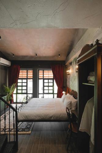 a bedroom with a large white bed with red curtains at The Chum Boutique in Hue