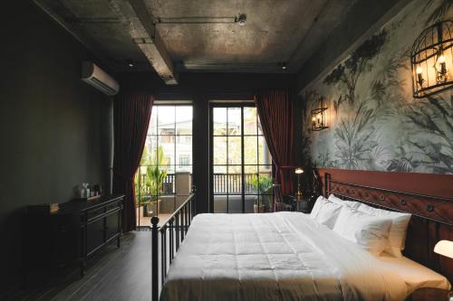 a bedroom with a bed and a large window at The Chum Boutique in Hue