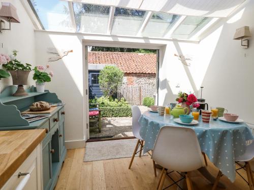 a kitchen with a table with a blue table cloth at Bridge Cottage in Norwich