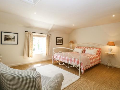 a bedroom with a bed and a couch and a window at Bridge Cottage in Norwich