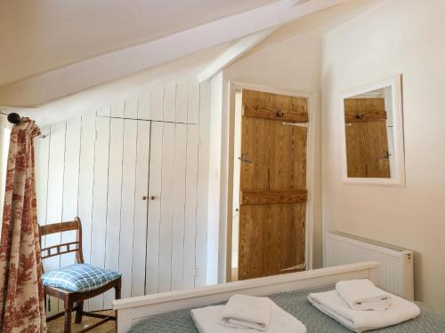 una camera con letto, sedia e specchio di Bridge Cottage a Norwich