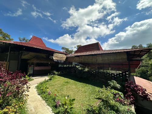 a building with a red roof and a yard at Munduk Tutub waterfall view in Munduk