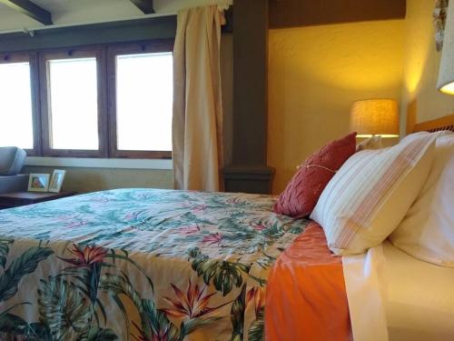 ein Schlafzimmer mit einem großen Bett mit einer bunten Decke in der Unterkunft Hale Laule'a at Opihi Point - Oceanfront, Gated Estate in Hakalau