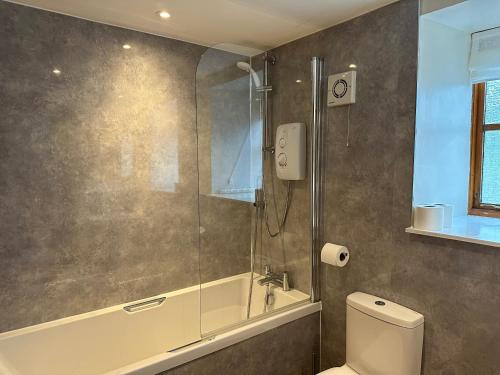 ein Bad mit einer Dusche und einem WC in der Unterkunft MacGregor in Pitlochry