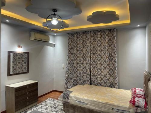 a bedroom with a bed and a dresser and a ceiling at شقق سكنيه رائعه الجمال تطل علي النيل in Cairo
