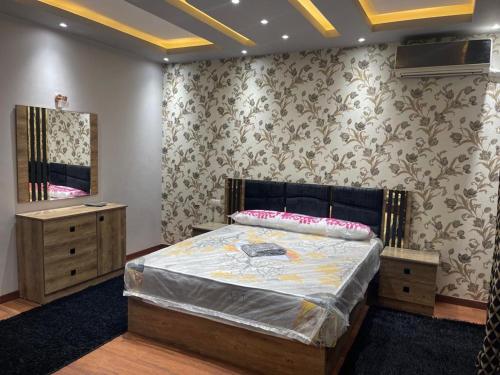 a bedroom with a large bed and a mirror at شقق سكنيه رائعه الجمال تطل علي النيل in Cairo