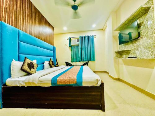 ニューデリーにあるHotel Aero Indus Near Airportのベッドルーム1室(大型ベッド1台、青いヘッドボード付)