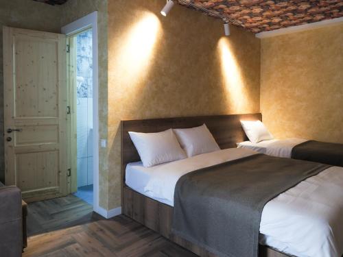 a bedroom with two beds and a hallway with a door at Hotel BaniHills Tbilisi in Tbilisi City