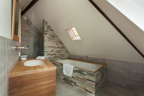 La salle de bains est pourvue d'un lavabo et d'un mur en briques. dans l'établissement La Paulowna Boutique Hotel, à La Haye