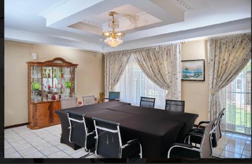 een eetkamer met een zwarte tafel en stoelen bij Oleratong Guest House in Evander