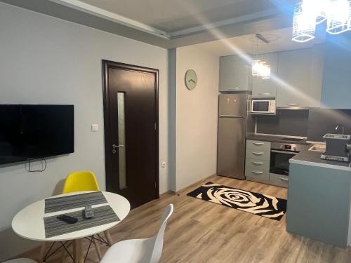 a small apartment with a table and a kitchen at Guest House Amaya Med in Plovdiv