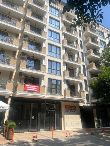 un gran edificio de apartamentos con un cartel en Guest House Amaya Med, en Plovdiv