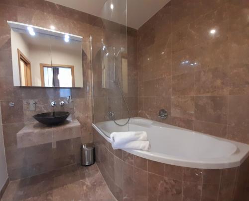 a bathroom with a bath tub and a sink at Residence Mariánská in České Budějovice