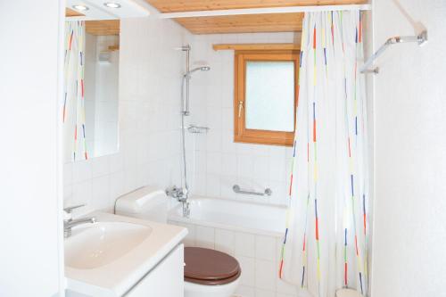 a bathroom with a tub and a sink and a toilet at 5 room house Joch Churwalden- Lenzerheide in Churwalden