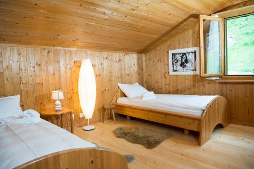 una camera con 2 letti in una cabina di legno di 5 room house Joch Churwalden- Lenzerheide a Churwalden