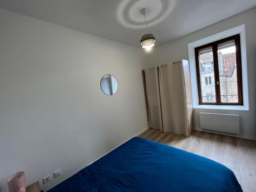 une chambre avec un lit bleu et une fenêtre dans l'établissement Appartement centre-ville de Lure gauche, à Lure
