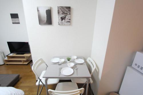 a small white table with white chairs in a room at LUANA NOGATA in Tokyo