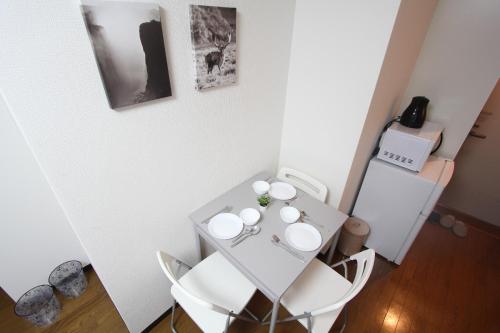 a small white table with white chairs in a room at LUANA NOGATA in Tokyo
