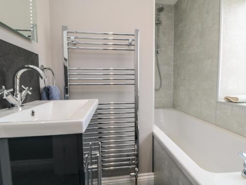 a bathroom with a sink and a bath tub at 2 Staveley Cottages in Weaverthorpe