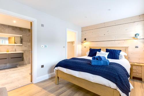 um quarto com uma cama grande e toalhas azuis em Breakers View em Wadebridge