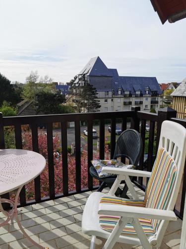 un patio avec deux chaises et une table sur un balcon dans l'établissement Cabourg cosy, appartement refait à neuf, 5 min à pied de la mer, à Cabourg