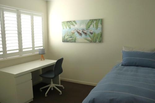 a bedroom with a desk and a bed and a desk and chair at Clifton Beach Retreat - 2 bed 2 bath apartment in Clifton Beach