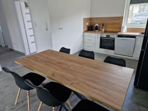 a kitchen with a wooden table and chairs at GaLu- Trelkowko 1 in Kobyłocha
