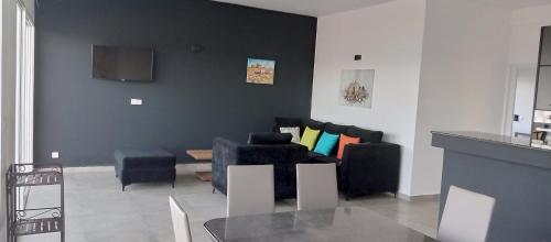 a living room with black chairs and a couch at Résidence ÉBÈNE - Villas in Antsakomboena