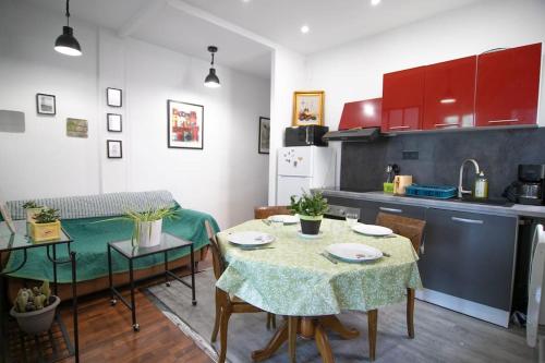 une cuisine avec une table et des chaises et une cuisine avec des placards rouges dans l'établissement FLC-2 ROOMS, 6p, Lift, Balconies, Quiet, STATION 5 mins, à Marseille