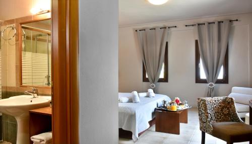 ポルタリアにあるHotel Pelion Resortのベッドとバスルーム付きのホテルルームです。