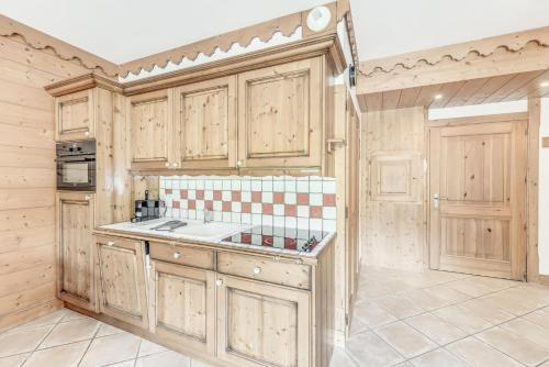 - une cuisine avec des placards en bois et un mur carrelé dans l'établissement Résidence Les Alpages - 2 Pièces pour 4 Personnes MAE-3944, à Champagny-en-Vanoise