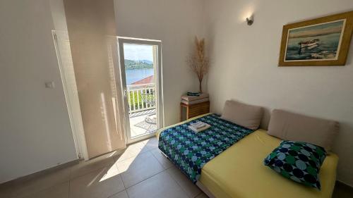 Un dormitorio pequeño con una cama y una ventana. en Seaview and relax, en Korčula