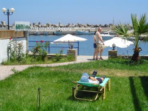 une personne allongée dans une chaise de jardin dans l'herbe dans l'établissement Kiveli, à Milatos